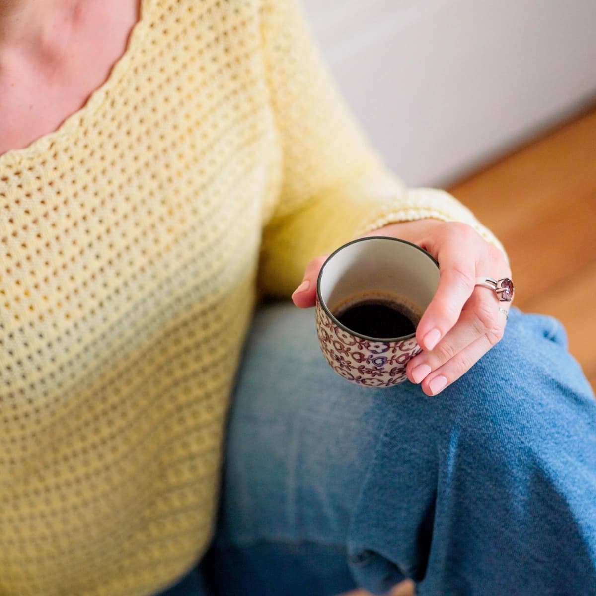 Détail des mains d'une sophrologue tenant une tasse de café