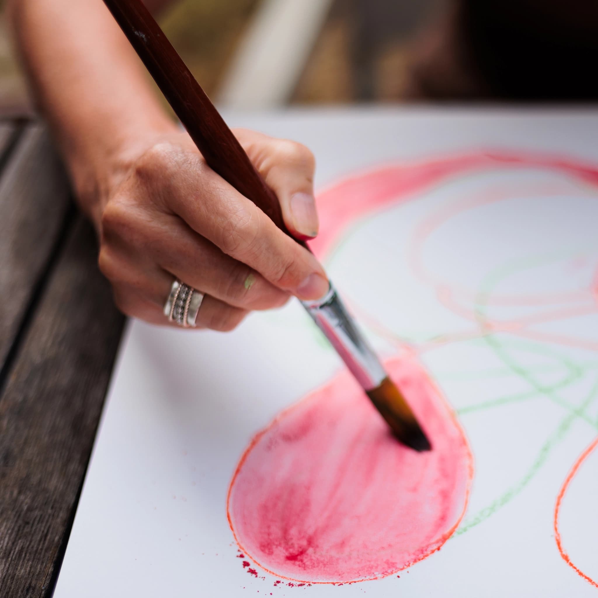 Détail d'un pinceau peignant un cercle de couleur, geste d'une artiste peintre