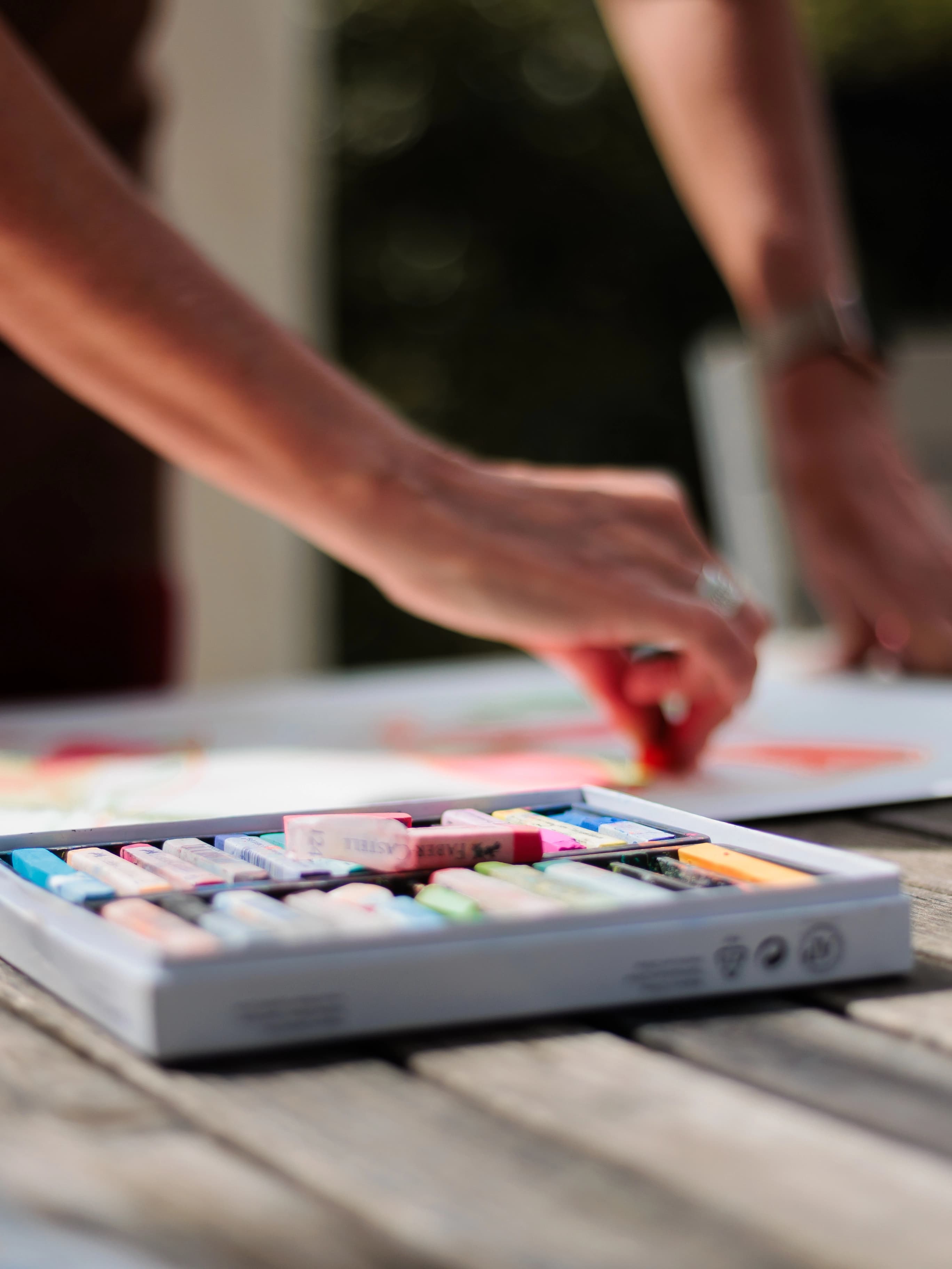 Détail des mains d'une artiste travaillant sa palette de couleurs