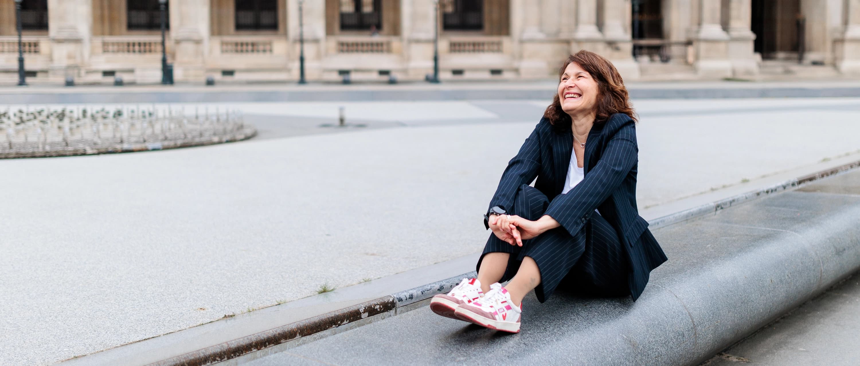 Portrait pro d'une experte en prévention santé assise sur un muret